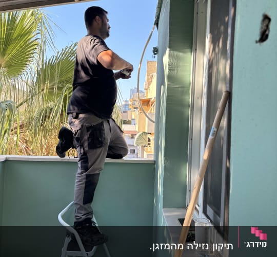 אדם עובד על התקנת מזגן במרפסת